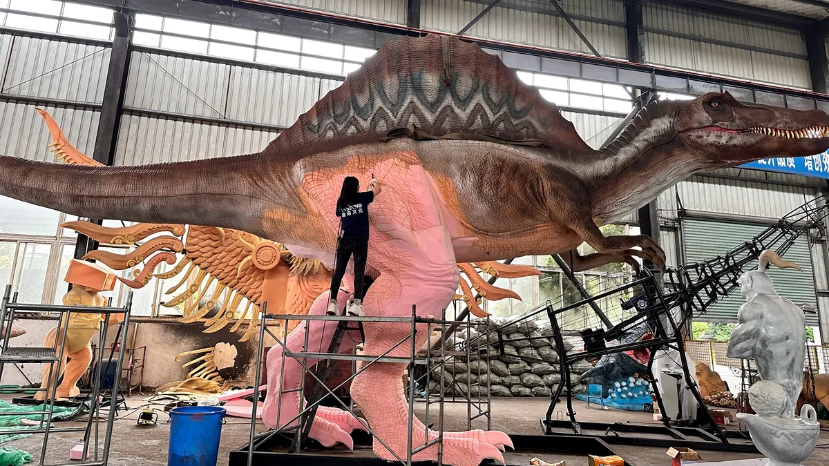 Foam sculpting and skin fitting of a giant animatronic dinosaur on the production line